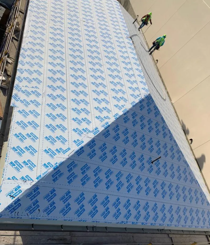 Professional roofers installing underlayment on a metal roof in Lake Wisconsin